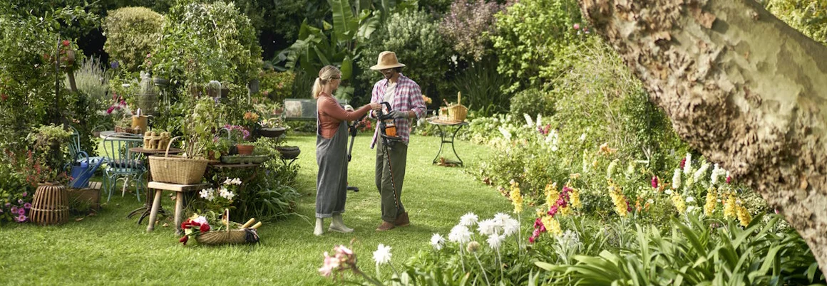 Zwei Personen im Garten mit Heckenschere
